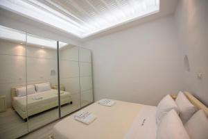 una camera con due letti e uno specchio di Casa di Vito a Mykonos Città