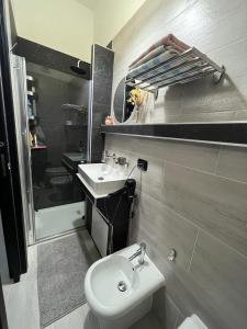 a bathroom with a sink and a toilet and a mirror at Light Home in Avellino