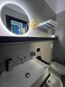 uma casa de banho com um lavatório, um espelho e um WC. em Light Home em Avellino