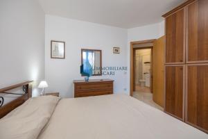 sypialnia z dużym łóżkiem i drewnianą szafką w obiekcie Villa Siragusa con piscina condominiale w mieście Campofelice di Roccella