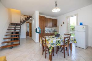 kuchnia i jadalnia ze stołem i krzesłami w obiekcie Villa Siragusa con piscina condominiale w mieście Campofelice di Roccella