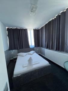 a room with two beds in a room with curtains at Hotel Minion in Constanţa