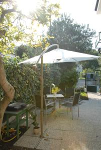 a table with a white umbrella and chairs at Da Irene in Mestre