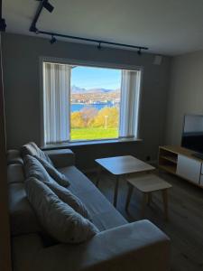 a living room with a couch and a large window at Panorama in Tromsø