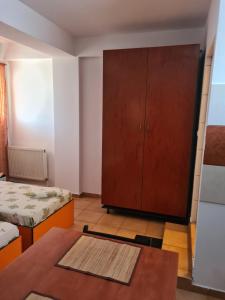 a room with two beds and a cabinet and a table at OGADUGU in Bucharest