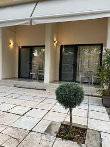 a house with a patio with a tree in front of it at Sun's Suites in Asprovalta