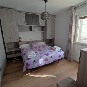 1 dormitorio con 1 cama con edredón morado en La casita de Sofia, en Gijón