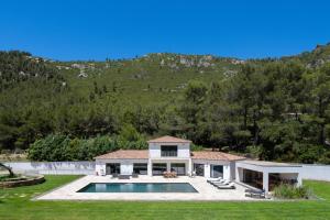 widok na dom z basenem w obiekcie VILLA KOÏ CASTELLET*PISCINE*SPA*SALLE DE SPORT*CINÉMA* w mieście Cuges-les-Pins