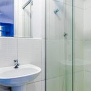 een badkamer met een wastafel en een glazen douche bij Club Suites - Aeroporto Congonhas in Sao Paulo