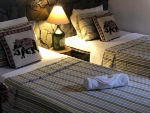 Habitación de hotel con 2 camas y almohada en la cama en Pousada Hosp Cantinho de Minas en Cabo Frío