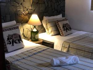 una habitación de hotel con 2 camas y una lámpara en Pousada Hosp Cantinho de Minas, en Cabo Frío