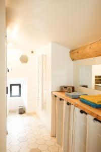 a white kitchen with a counter and a room at La Grange 1832 - A 10 mins d'Aubenas in Saint-Étienne-de-Boulogne