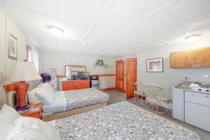 1 dormitorio con 2 camas y cocina con mesa en Sebago Suite, en Standish