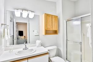 een witte badkamer met een wastafel en een douche bij Home with enclosed yard, fire pit, WiFi, W/D, & AC - great location in Villano Beach +28 foto's