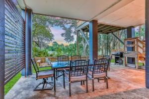 een terras met een tafel en stoelen en een barbecue bij Home with enclosed yard, fire pit, WiFi, W/D, & AC - great location in Villano Beach