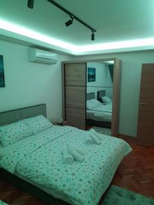a bedroom with two beds and a large mirror at Holiday apartaments 2 in Niš
