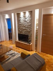 a living room with a couch and a flat screen tv at Holiday apartaments 2 in Niš