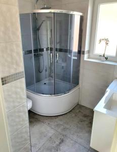 W łazience znajduje się prysznic ze szklanymi drzwiami. w obiekcie AThome w mieście Czchów