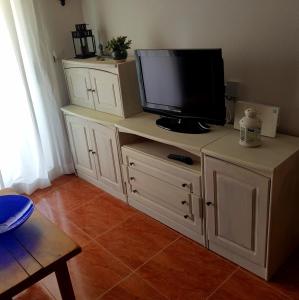 a white entertainment center with a tv on top of it at Cabo de Palos Apartment in Cabo de Palos