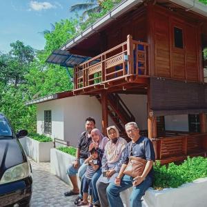 a group of people sitting in front of a tiny house at Hometostay Bokbak Kupang 