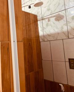 a bathroom with a shower with a wooden door at RESIDENCIAL OLIVEIRA in Manaus