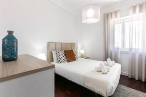 una camera da letto bianca con un letto e una finestra di Casa da Marginal a Peniche