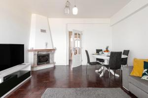 un soggiorno con tavolo e camino di Casa da Marginal a Peniche