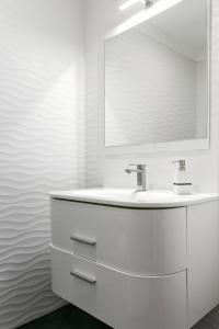 un bagno bianco con lavandino e specchio di Casa da Marginal a Peniche