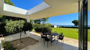 a patio with a table and chairs on it at Seaside Villa Hoopoe just steps from the beach in Schinias