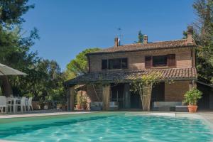 una casa con piscina frente a una casa en Villa Panorama 9 en Pesaro