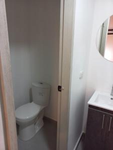 a small bathroom with a toilet and a sink at Ayenda Colombia Avenida in Medellín