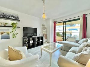 sala de estar con muebles blancos y TV de pantalla plana en Ricardo Soriano - EaW Homes, en Marbella