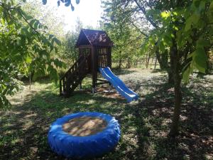 plac zabaw ze zjeżdżalnią i niebieską oponą w obiekcie Total Relax Apartmanház w Bogácsu