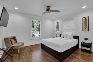 um quarto branco com uma cama e uma cadeira em Buckheaddream Atlanta6bdrms Wbath In Every Room em Atlanta