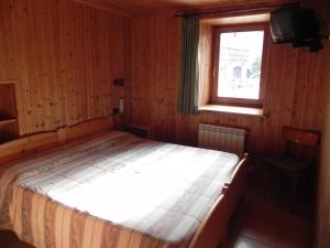 1 dormitorio con 1 cama en una habitación con ventana en Le Vieux Rascard Chambres d'Hotes, en Champoluc