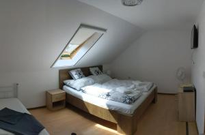a small bedroom with a bed with a skylight at Margaréta Étterem és Vendéghàz Gasthaus in Balatonberény