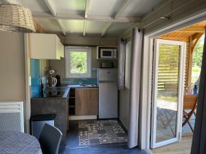a small kitchen with a sink and a refrigerator at Chalet au calme dans la pinède in La Teste-de-Buch