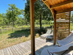 a wooden deck with two chairs and a gazebo at Chalet au calme dans la pinède in La Teste-de-Buch