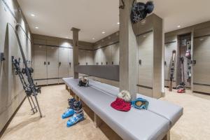 a long bench in a hockey locker room with skis at Hotel Le Tremplin in Méribel