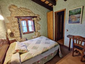 Llinars del VallèsにあるMasia Can Felip B&Bのベッドルーム1室(ベッド1台、窓、椅子付)