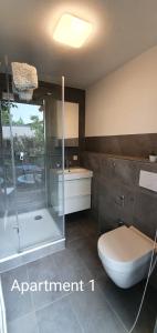 e bagno con doccia, servizi igienici e lavandino. di SEVIS Outlet Apartments a Metzingen