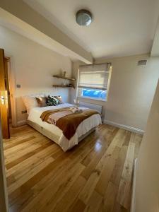 a bedroom with a bed and a wooden floor at Luxury Home Angel Station in London