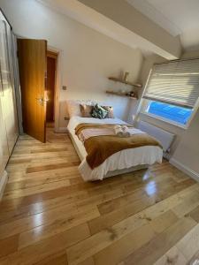 a bedroom with a bed and a wooden floor at Luxury Home Angel Station in London