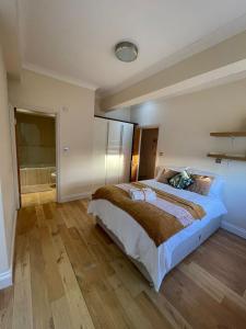 a bedroom with a large bed and a wooden floor at Luxury Home Angel Station in London