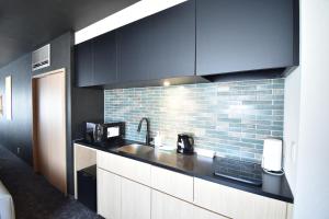 a kitchen with a sink and a brick wall at K-style gosyonishi in Shimmachidōri