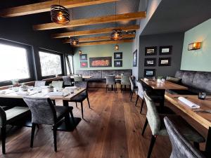 a dining room with tables and chairs and a fireplace at Landhaus Hohly in Löwenstein