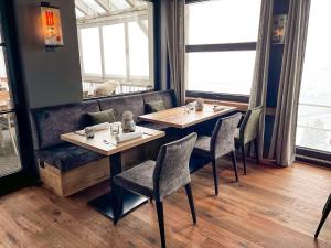 a restaurant with two tables and chairs and windows at Landhaus Hohly in Löwenstein