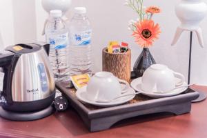 a table with a coffee maker and two cups on a tray at Ruanmata Homestay in Chiang Mai