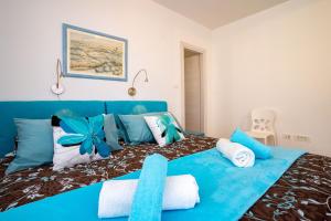 a blue bed with white and blue pillows on it at OlivaBeachHouse - Direct Waterfront & Mooring in Barbat na Rabu +67 photos
