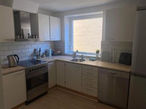 a kitchen with white cabinets and a sink and a window at Apartment in the heart of Aalborg in Aalborg